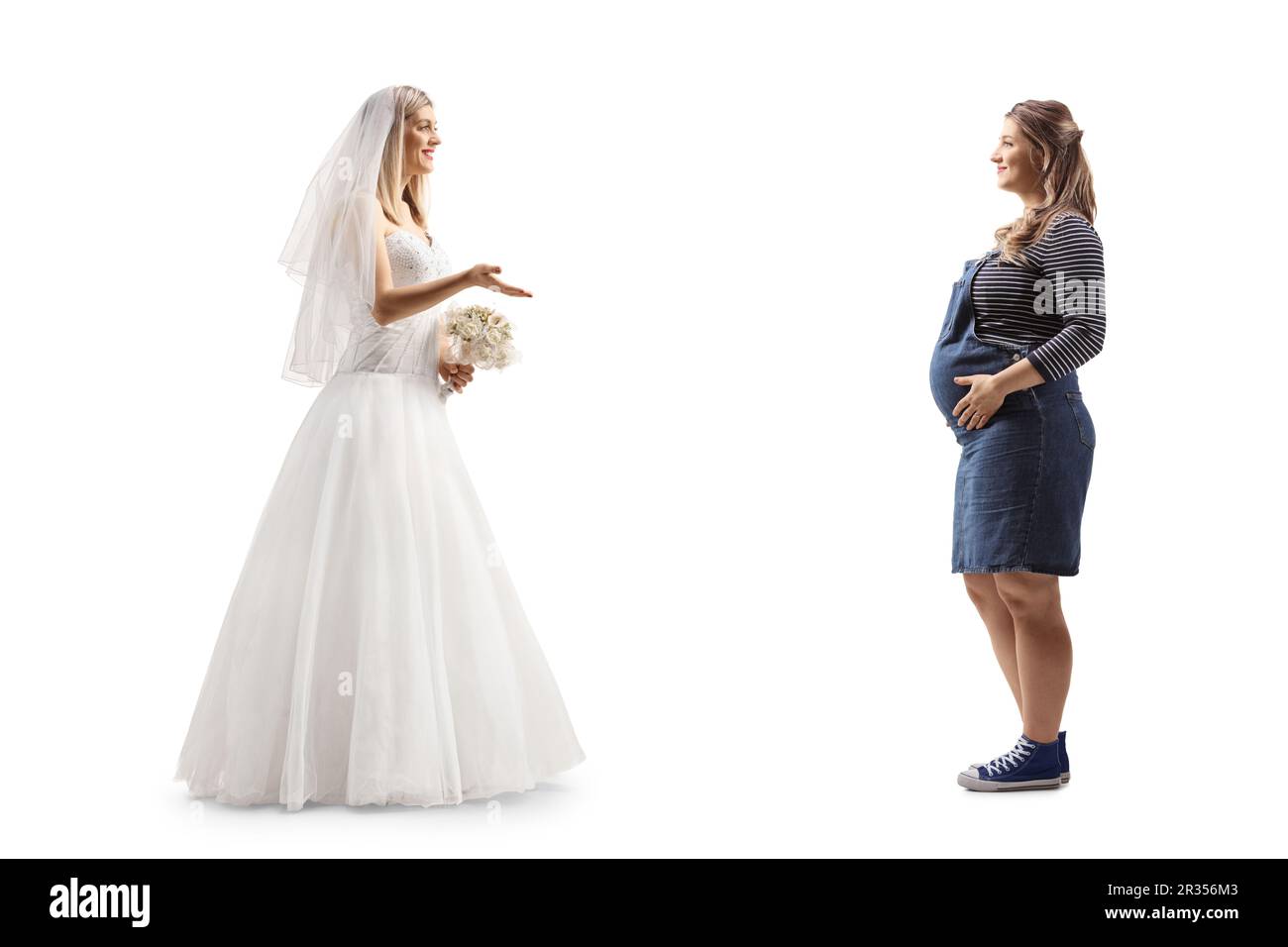 Photo de profil pleine longueur d'une mariée parlant à une femme enceinte isolée sur fond blanc Banque D'Images
