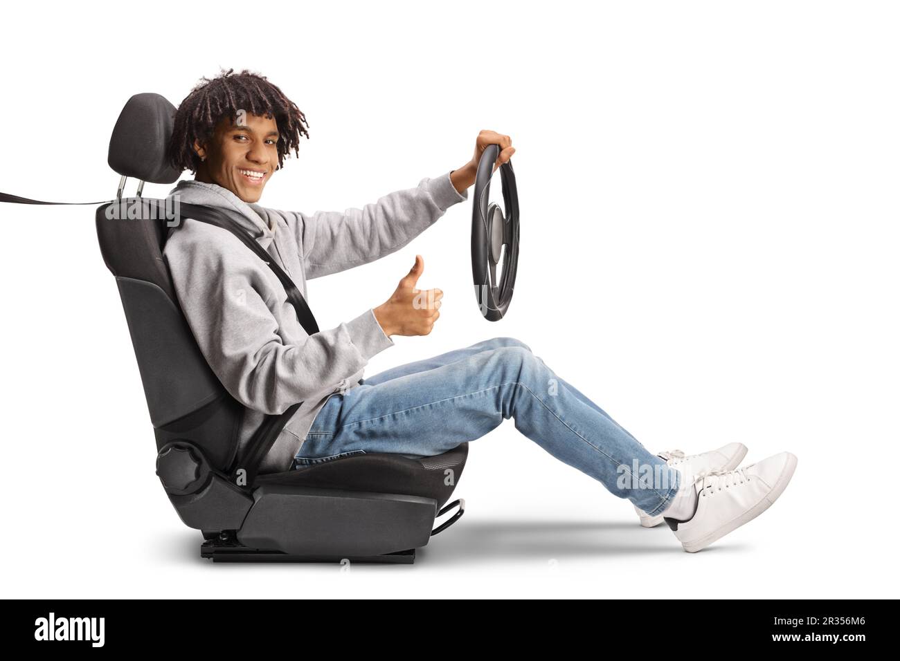 Un jeune homme afro-américain décontracté tenant un volant et faisant des gestes isolés sur fond blanc Banque D'Images