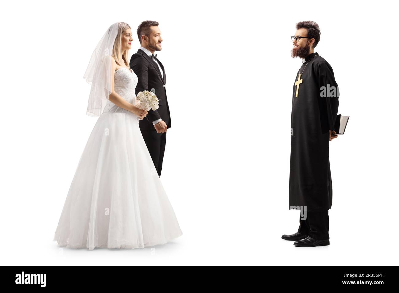 Photo pleine longueur d'un prêtre et d'une mariée et d'un marié isolés sur fond blanc Banque D'Images