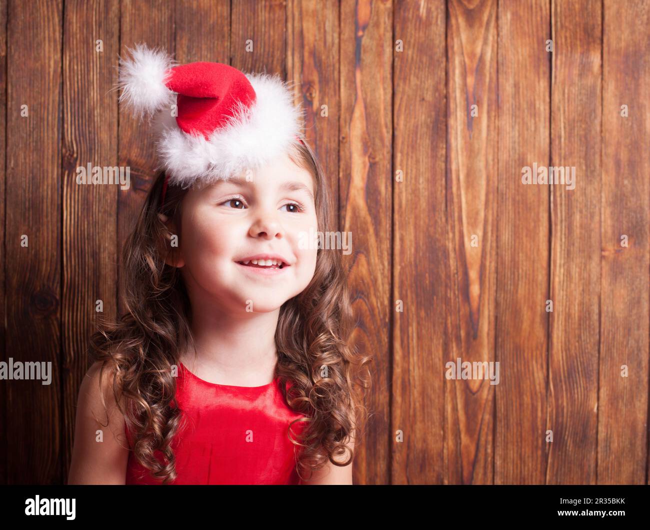 Serre-tête de fille en chapeau de père Noël assis sur un mur en bois,  espace de copie Photo Stock - Alamy