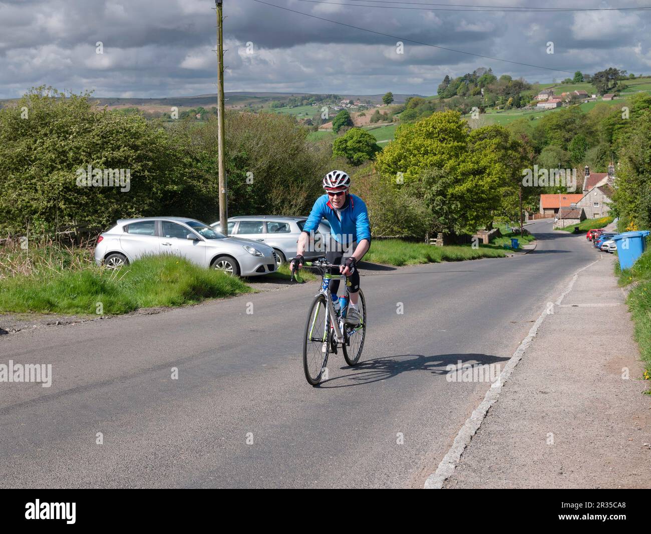Cycliste sportif montant une colline à la sortie de Danby dans le nord |Yorkshire Moors Banque D'Images