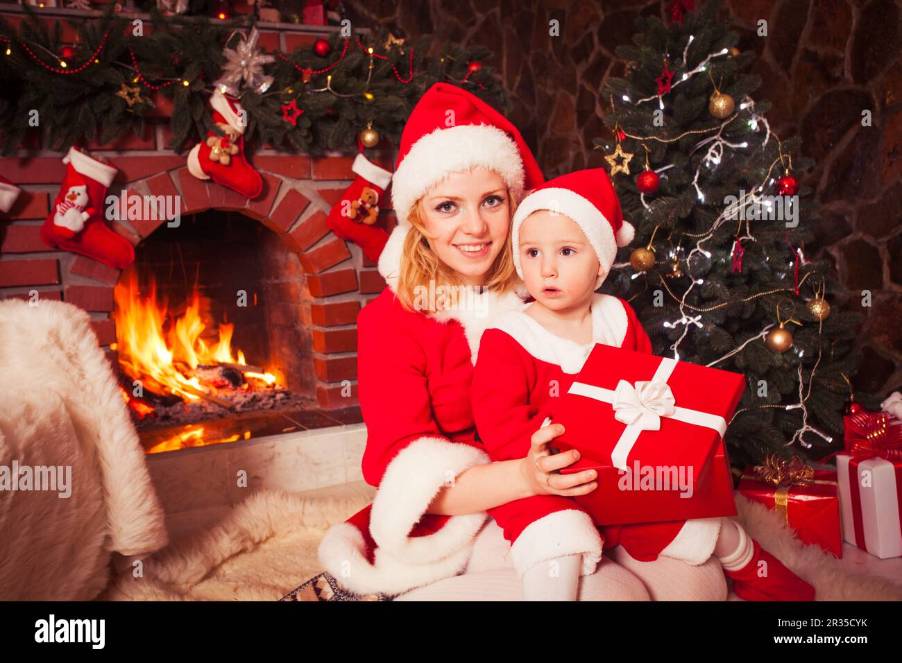 Mère et fils près de foyer de Noël Banque D'Images