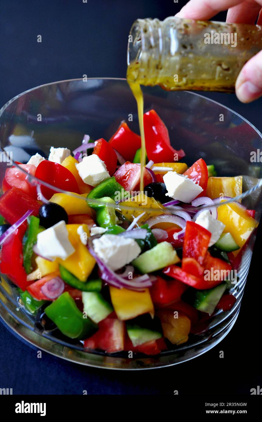 Vinaigrette versée sur une salade de légumes Banque D'Images
