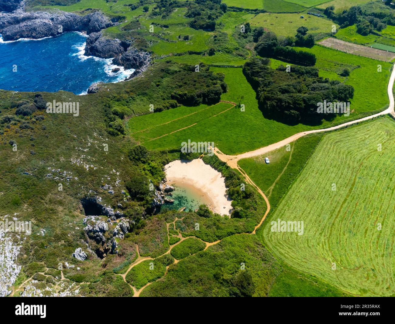 Vue aérienne sur la petite Playa de Gulpiyuri, gouffre inondé avec plage intérieure près de Llanes, dans les Asturies du nord de l'Espagne, à environ 100 m de la mer de Cantabrie, Banque D'Images