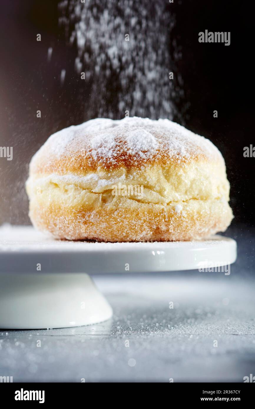 Un beignet saupoudré avec du sucre glace (gros plan) Banque D'Images