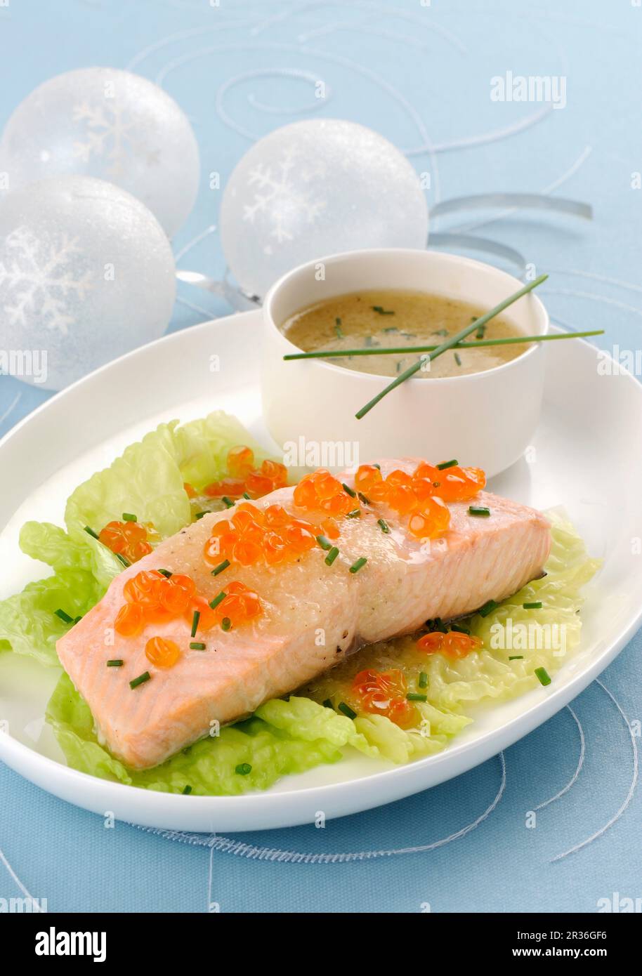 Filet de saumon cuit à la vapeur sur les feuilles de laitue avec caviar de saumon et ciboulette Banque D'Images
