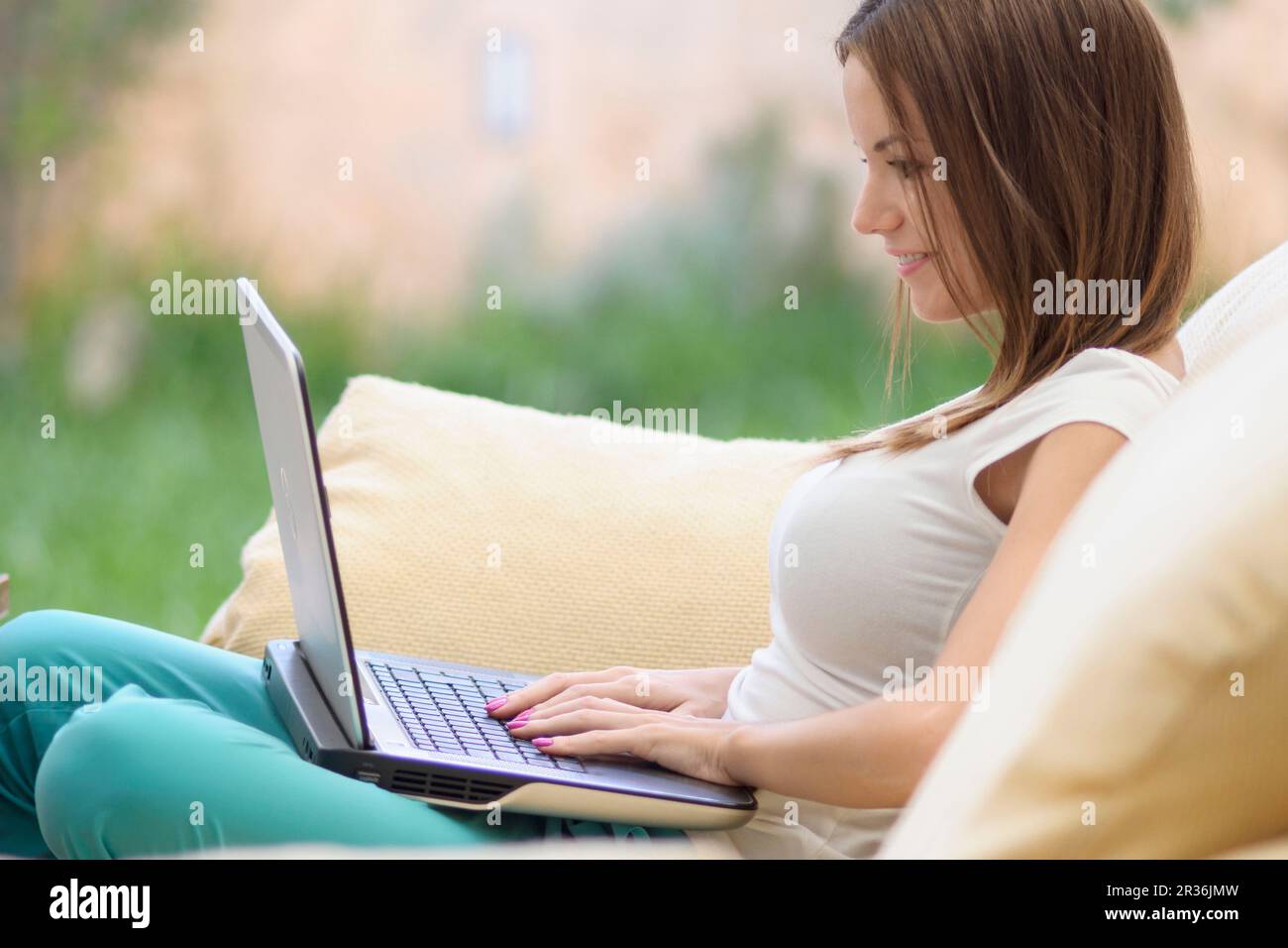 Mujer joven escribiendo en un ordenador portatil,islas baleares, Espagne. Banque D'Images