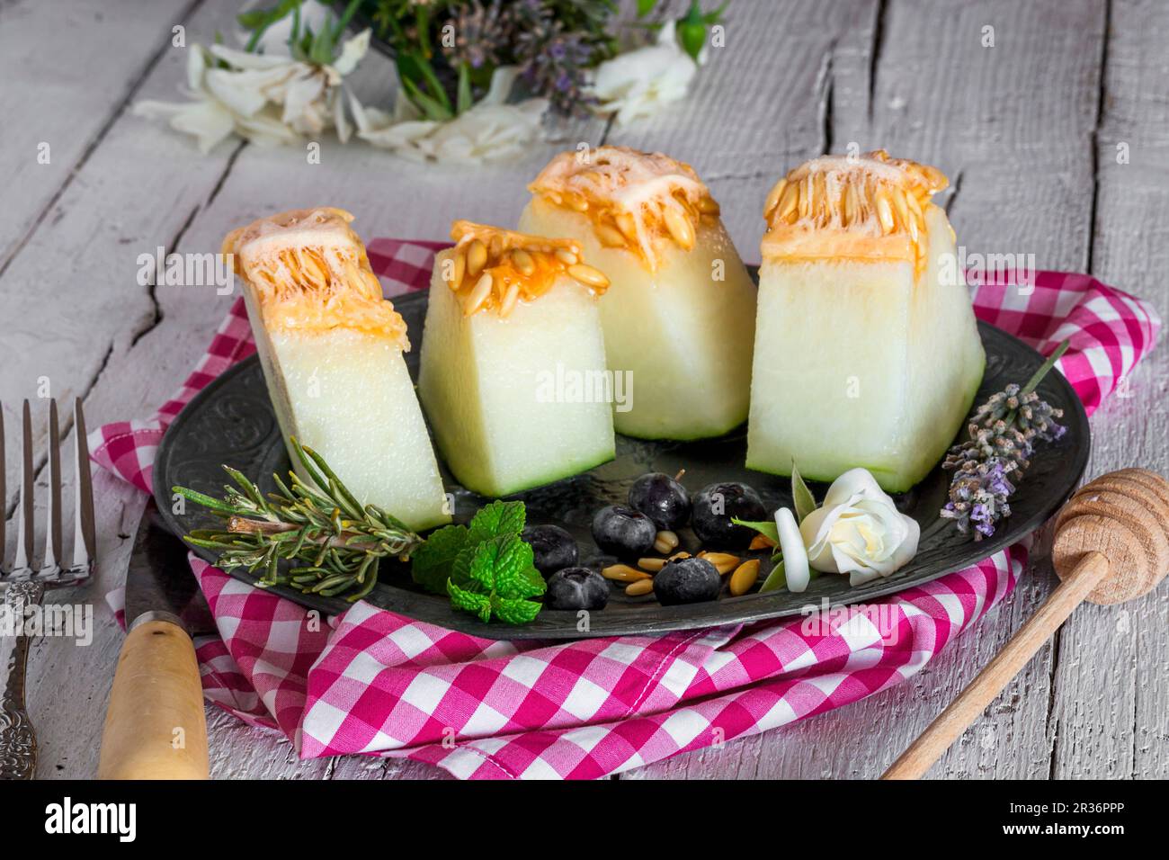 Morceaux de melon à la menthe, au romarin et aux bleuets Banque D'Images