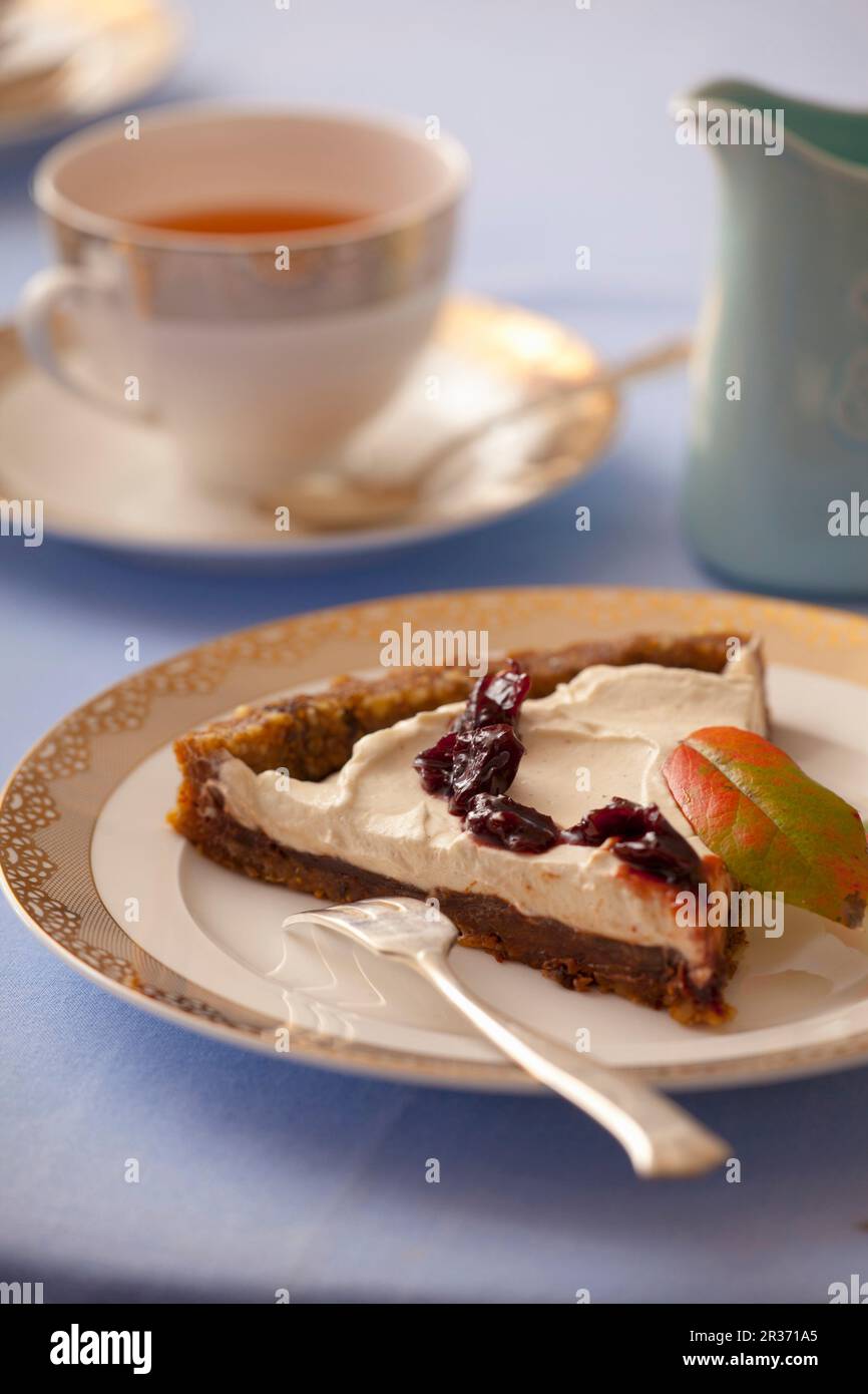 Une tranche de tarte aux dattes séchées, figues, noix, chocolat, crème et confiture Banque D'Images