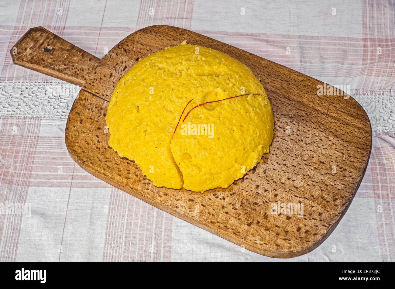 Polenta fraîche coupée avec une ficelle rouge sur un panneau en bois vintage Banque D'Images