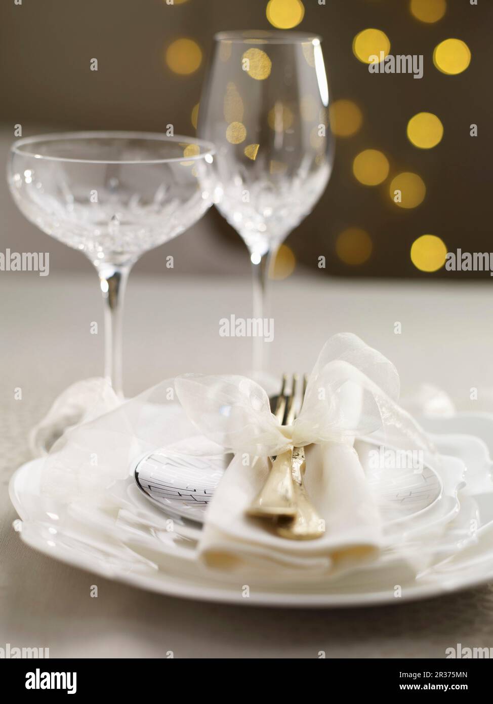 Table de Noël ornée d'un noeud blanc et de verres en cristal Banque D'Images