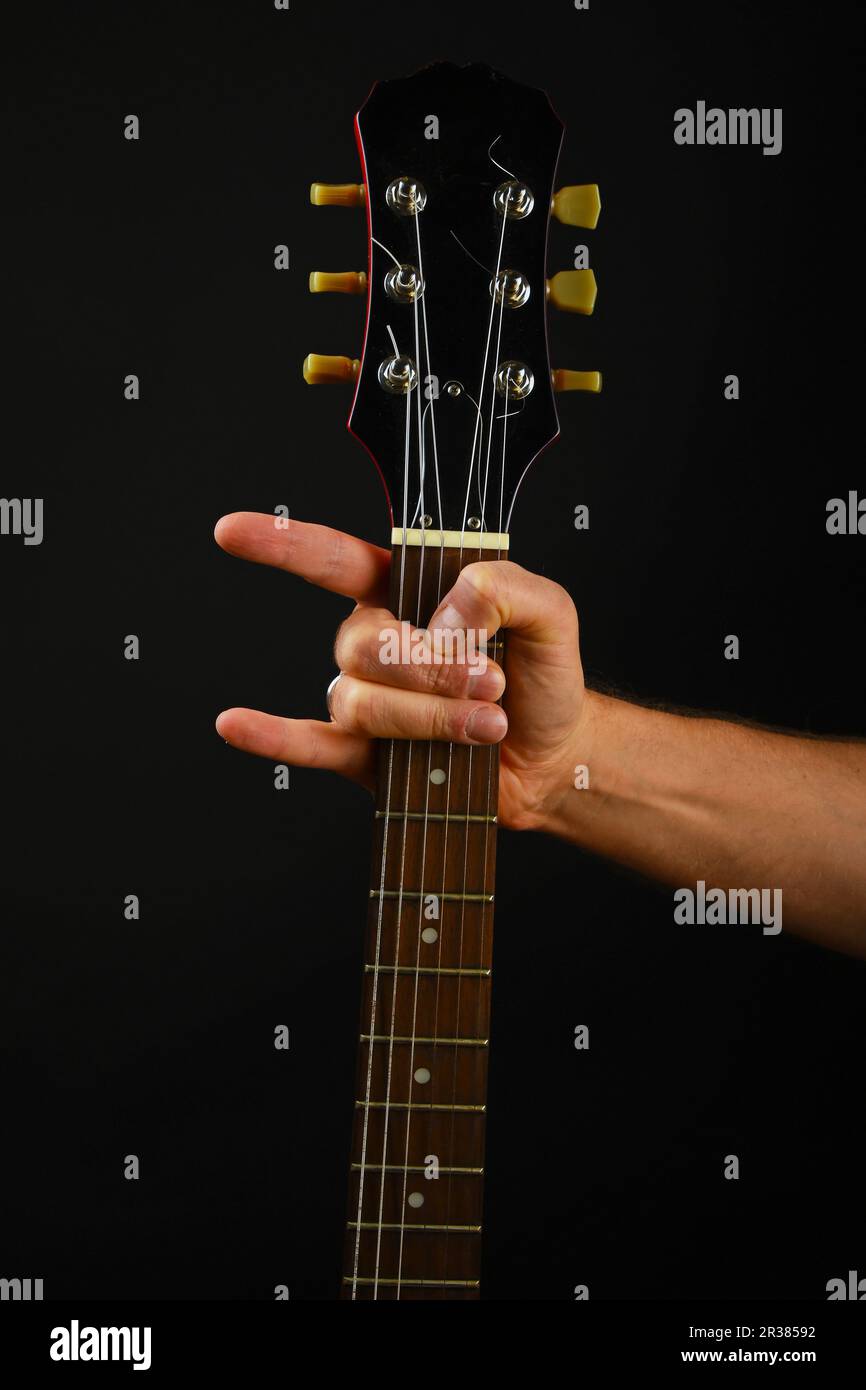 Part avec guitare et devil horns isolated on black Banque D'Images