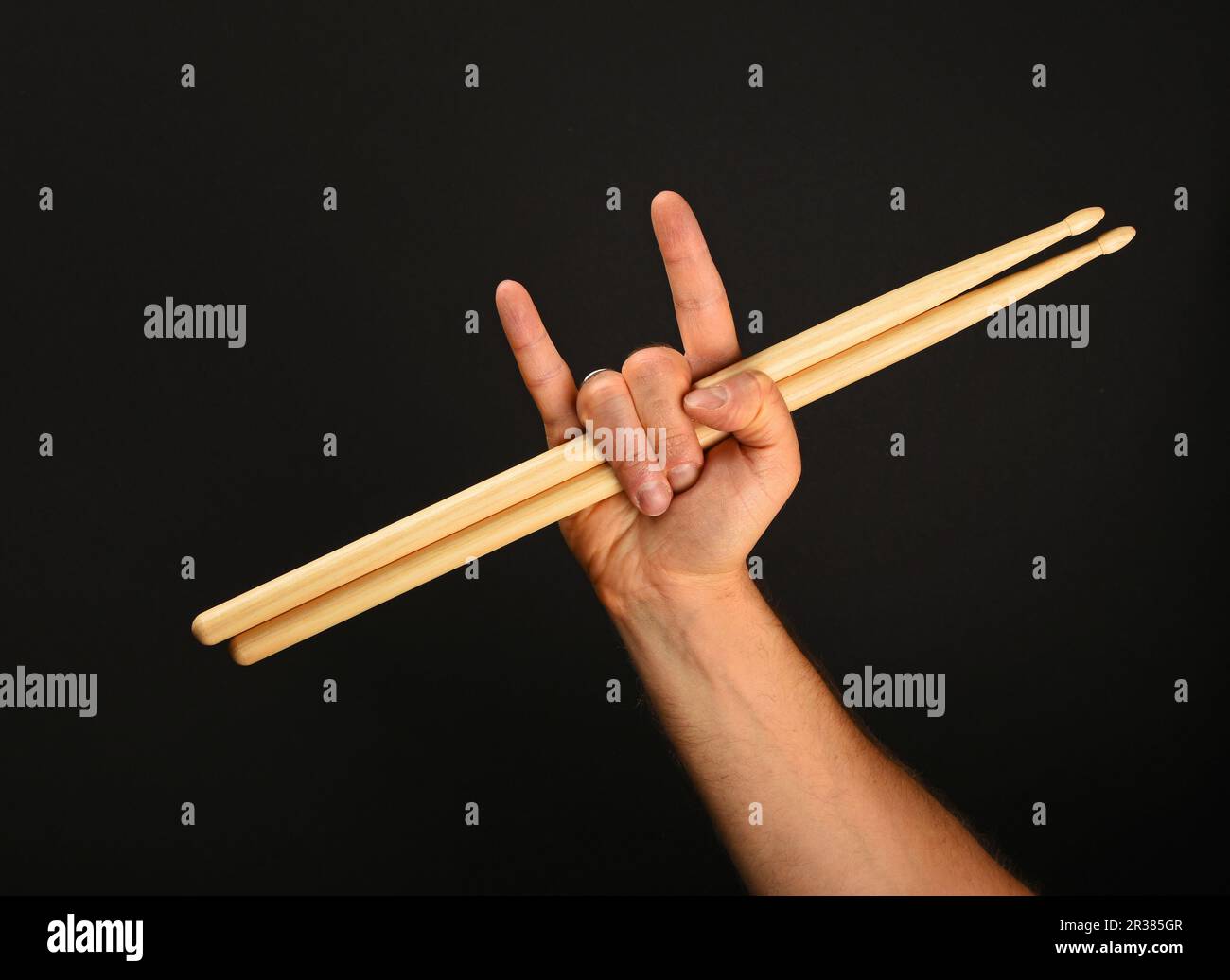 Main d'homme avec des pilons et des cornes de diable sur noir Banque D'Images