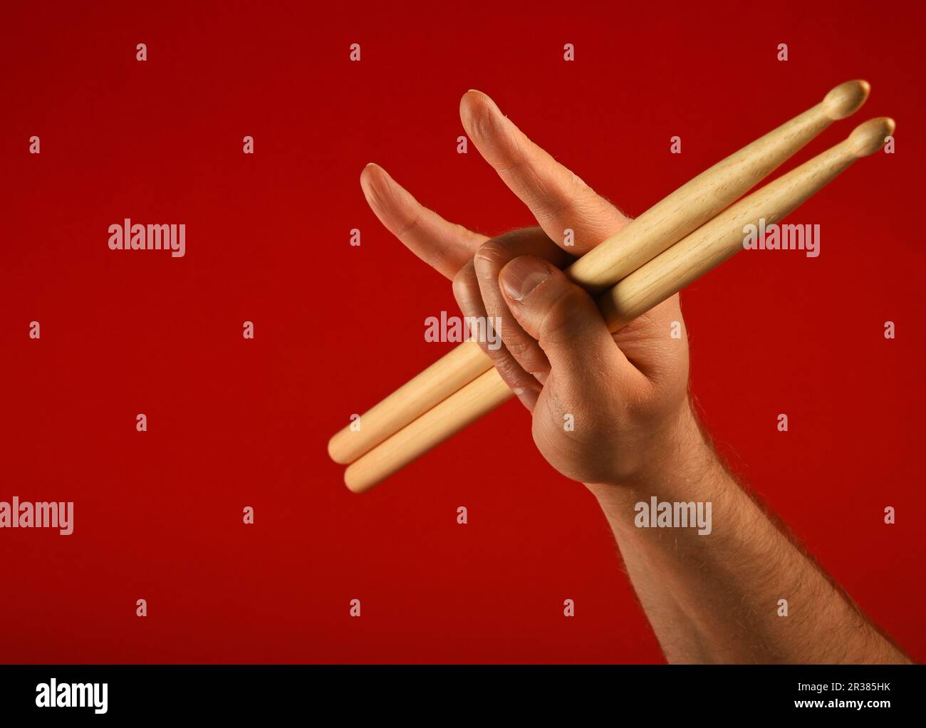 Main d'homme avec des pilons et des cornes de diable sur rouge Banque D'Images