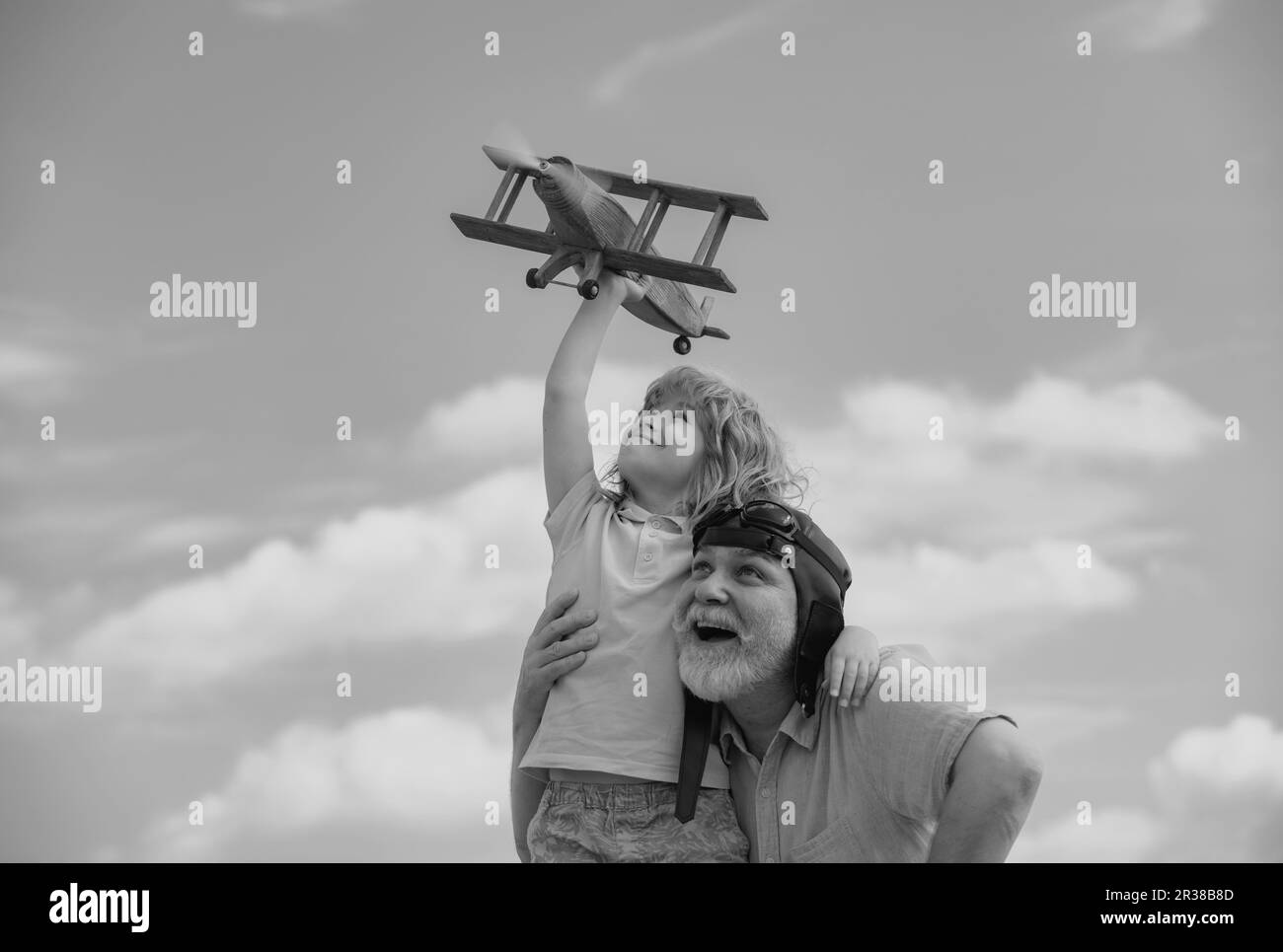 Grand-père et petit-fils jouant avec l'avion ensemble sur le ciel bleu. Enfant mignon avec grand-père jouant à l'extérieur. Banque D'Images