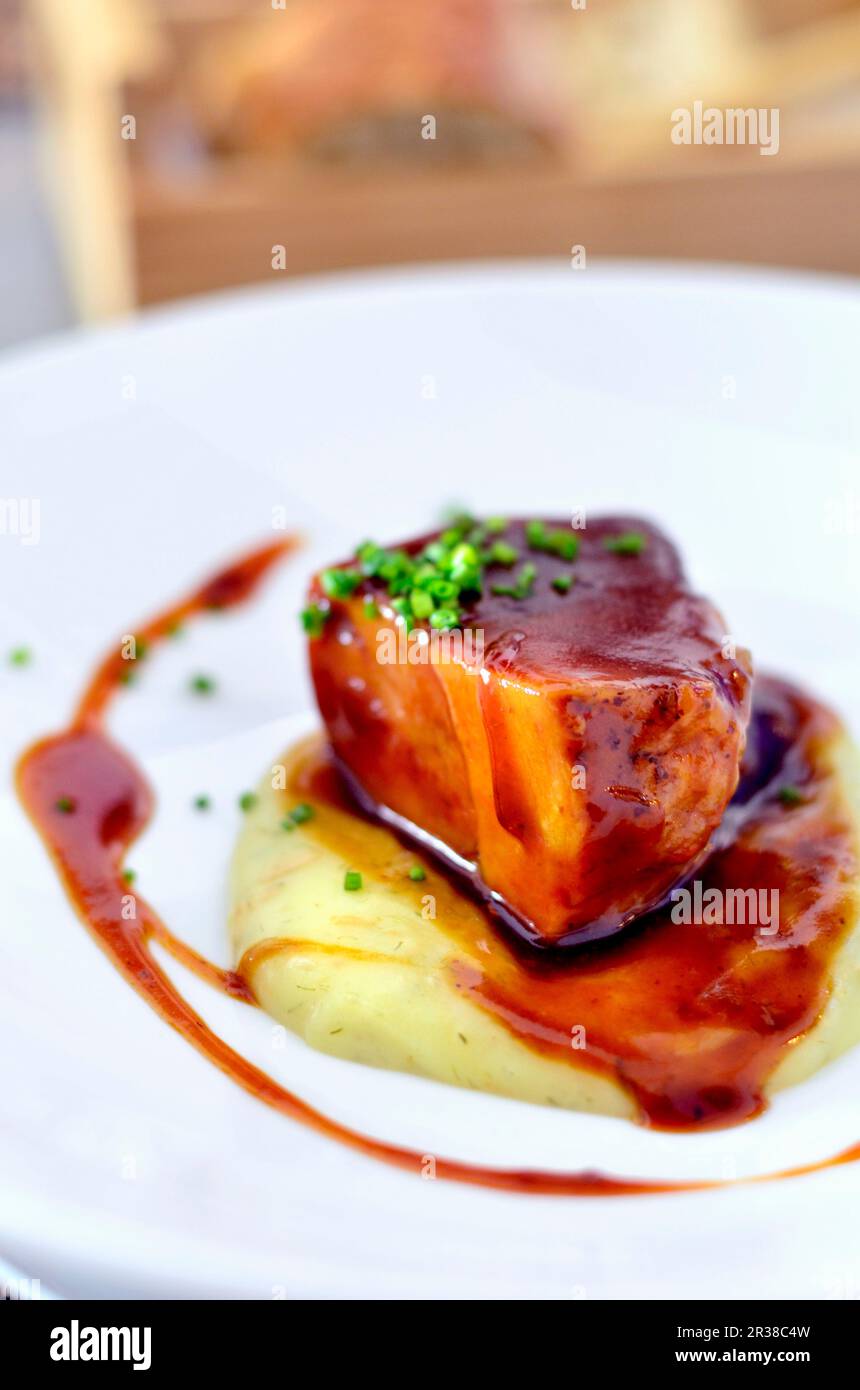 Poitrine de porc ibérique braisée avec sauce sur un lit de purée de pommes de terre Banque D'Images