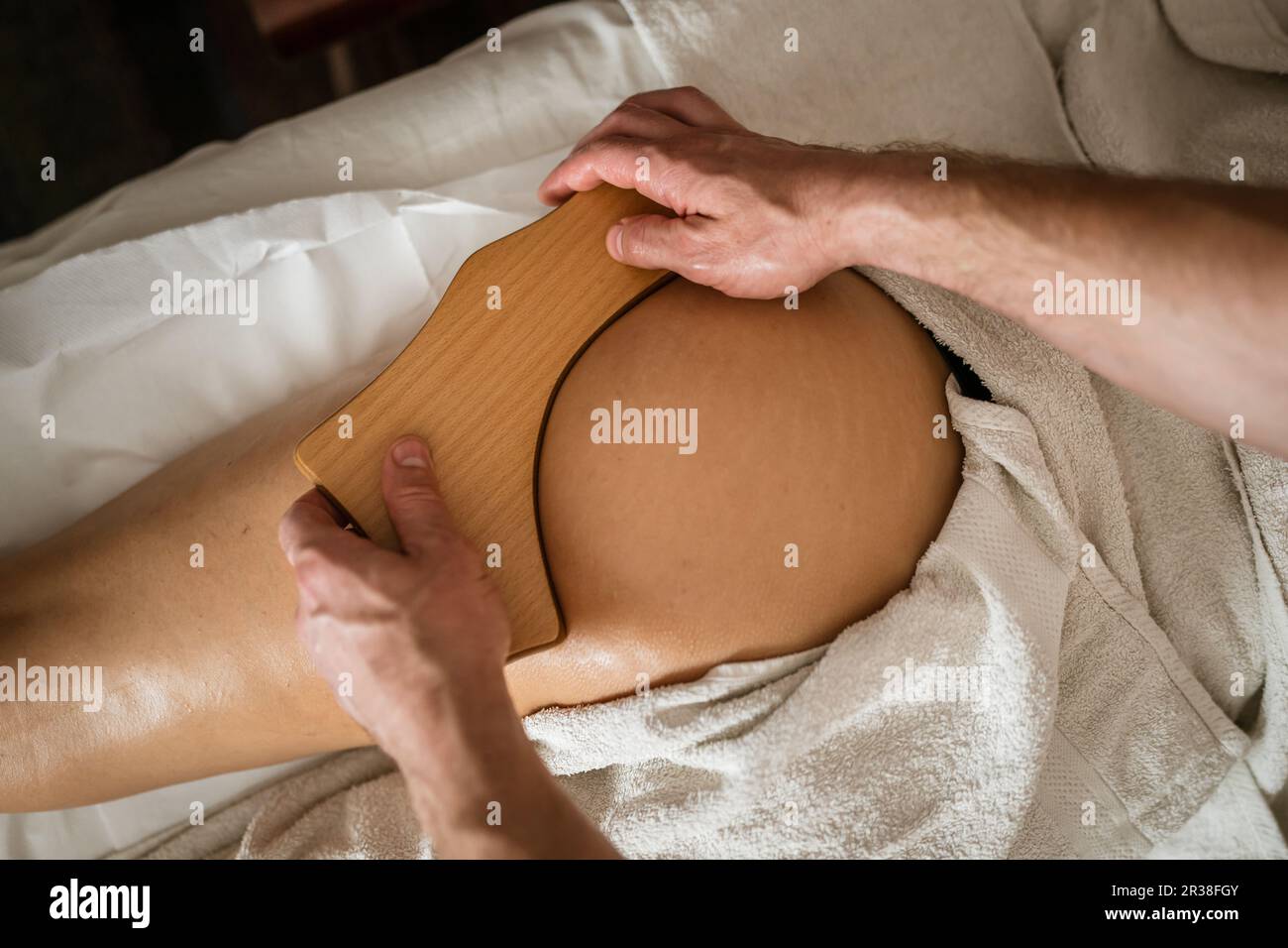 Inconnu Femme caucasienne ayant madero thérapie massage anti-cellulite traitement par thérapeute professionnel tenant des outils en bois dans les mains en studio ou sa Banque D'Images