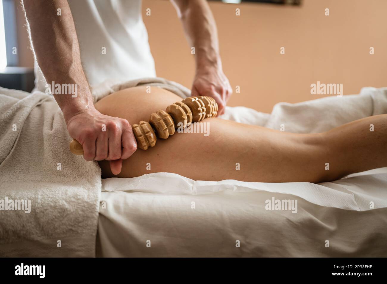 Inconnu Femme caucasienne ayant madero thérapie massage anti-cellulite traitement par thérapeute professionnel tenant des outils en bois dans les mains en studio ou sa Banque D'Images
