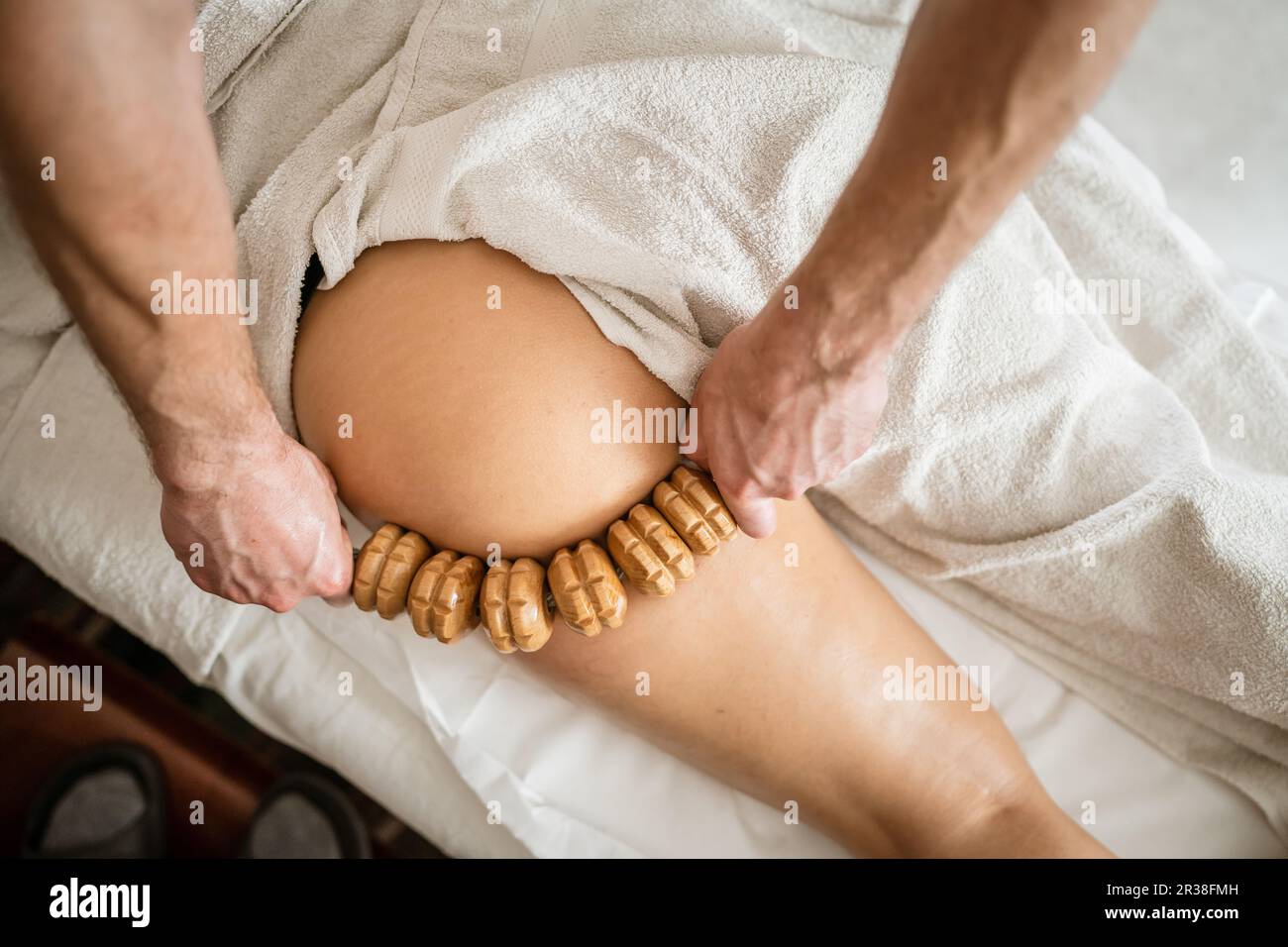Inconnu Femme caucasienne ayant madero thérapie massage anti-cellulite traitement par thérapeute professionnel tenant des outils en bois dans les mains en studio ou sa Banque D'Images