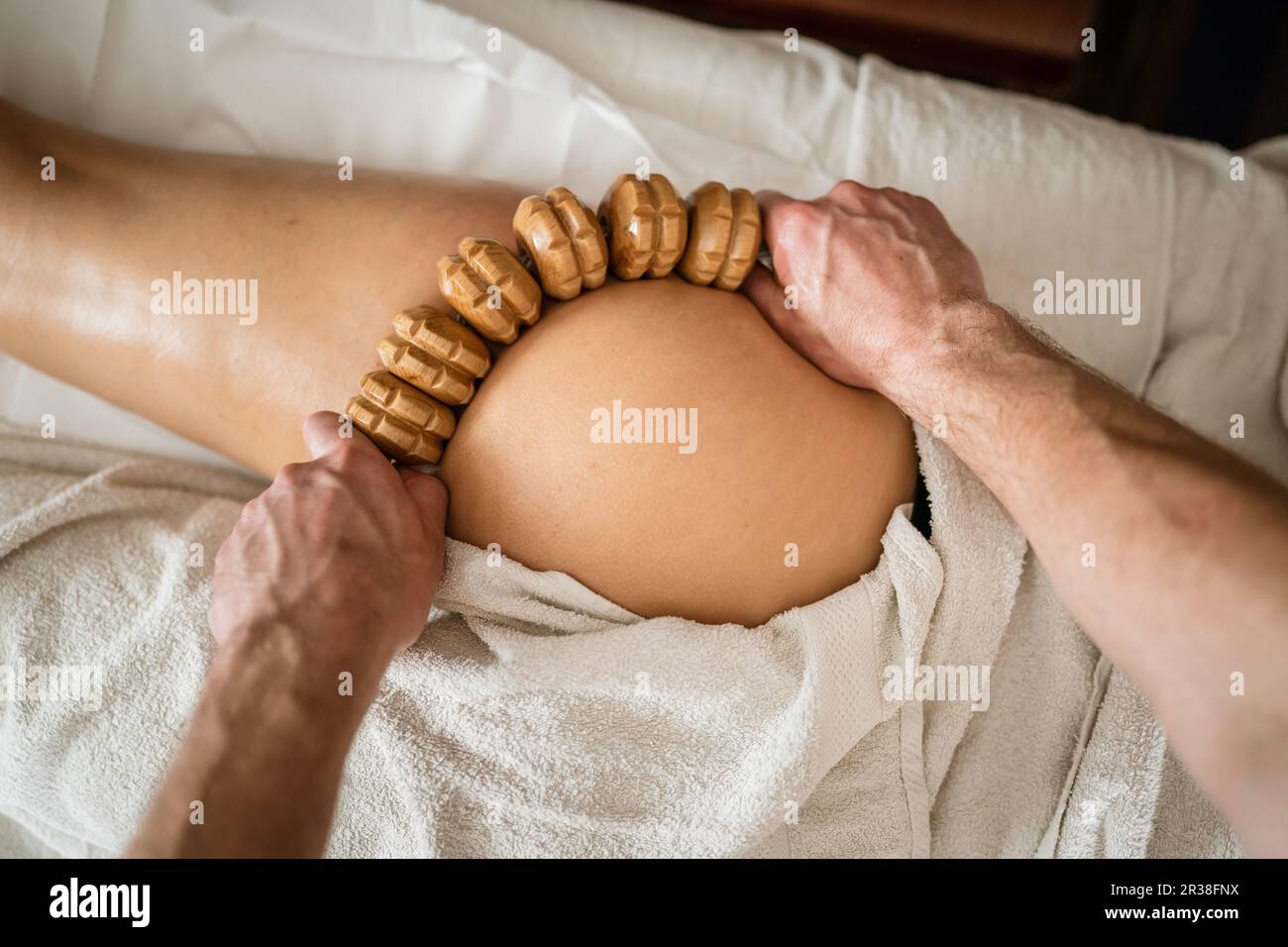 Inconnu Femme caucasienne ayant madero thérapie massage anti-cellulite traitement par thérapeute professionnel tenant des outils en bois dans les mains en studio ou sa Banque D'Images