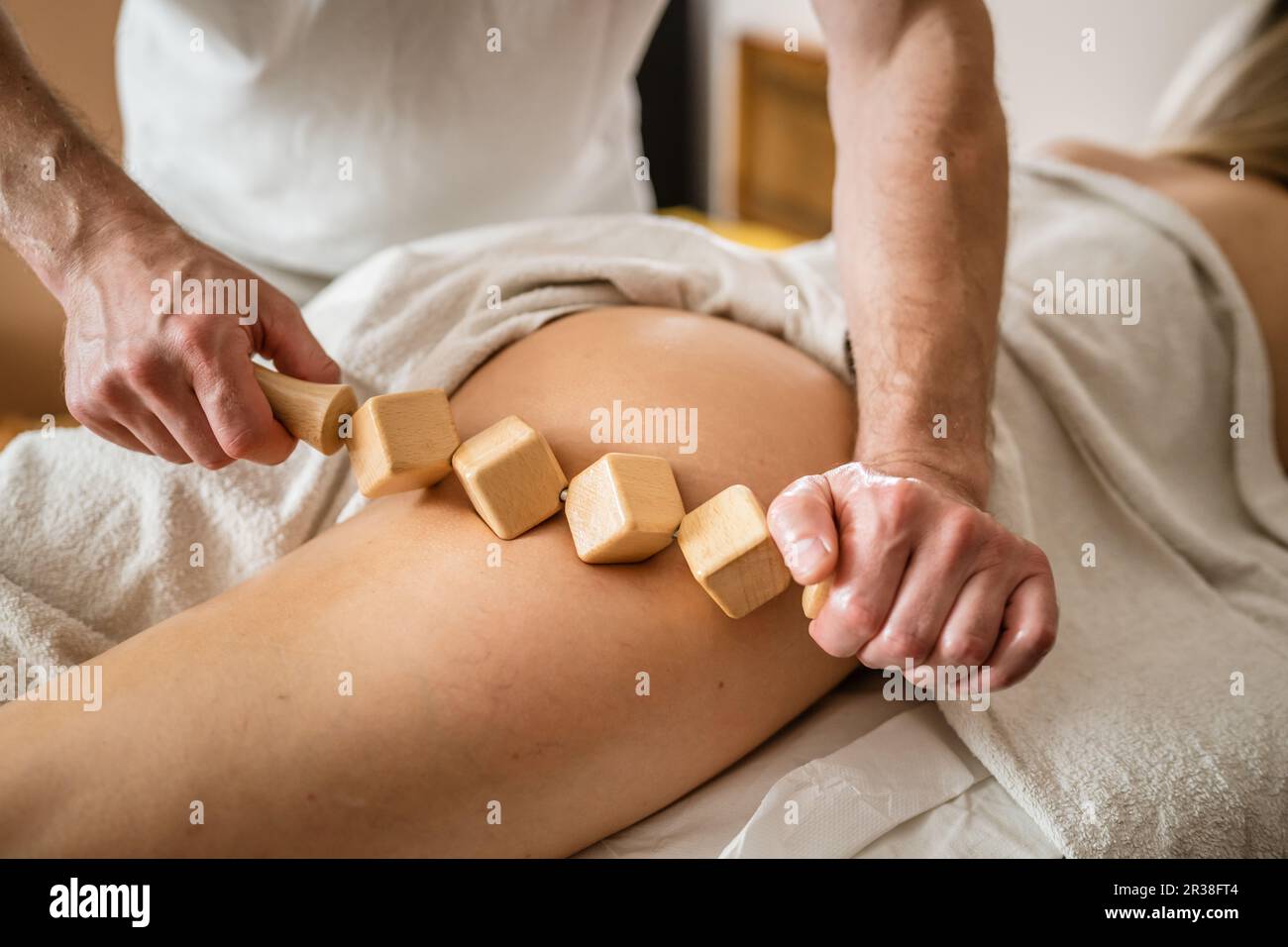 Inconnu Femme caucasienne ayant madero thérapie massage anti-cellulite traitement par thérapeute professionnel tenant des outils en bois dans les mains en studio ou sa Banque D'Images