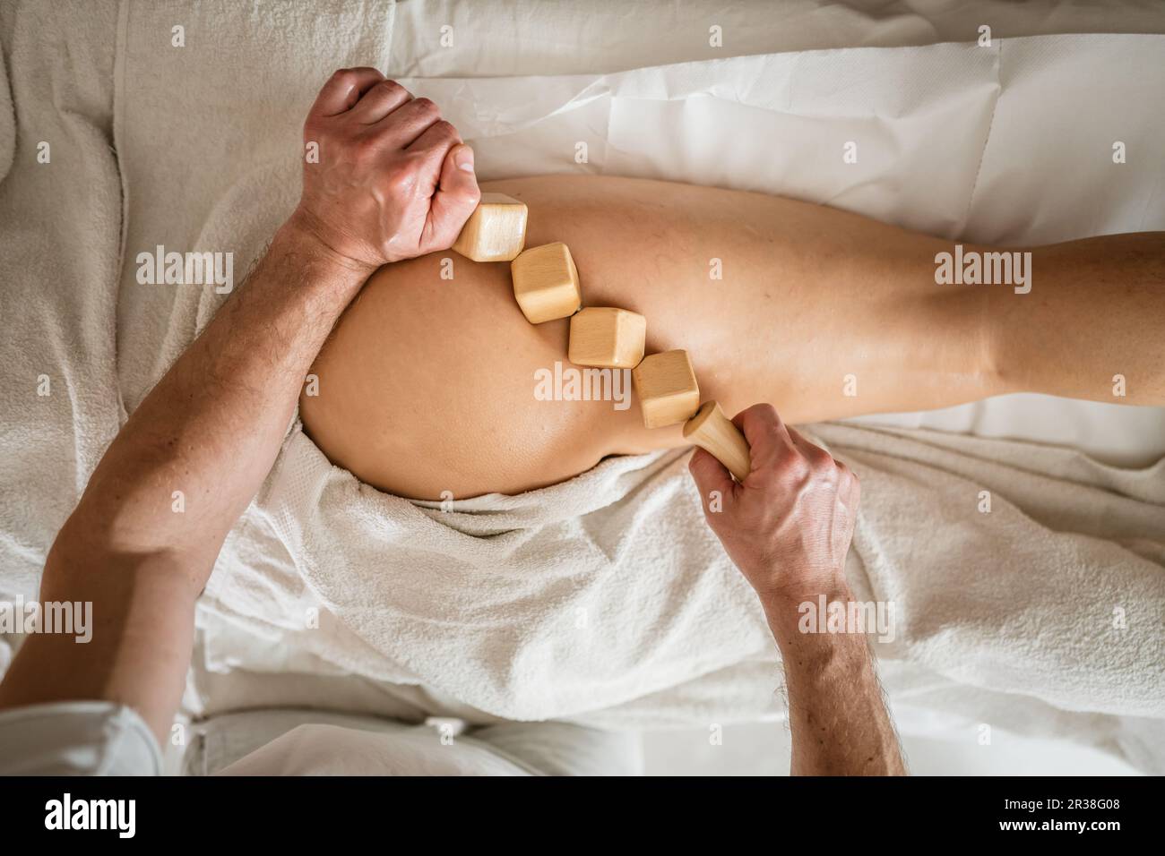 Inconnu Femme caucasienne ayant madero thérapie massage anti-cellulite traitement par thérapeute professionnel tenant des outils en bois dans les mains en studio ou sa Banque D'Images