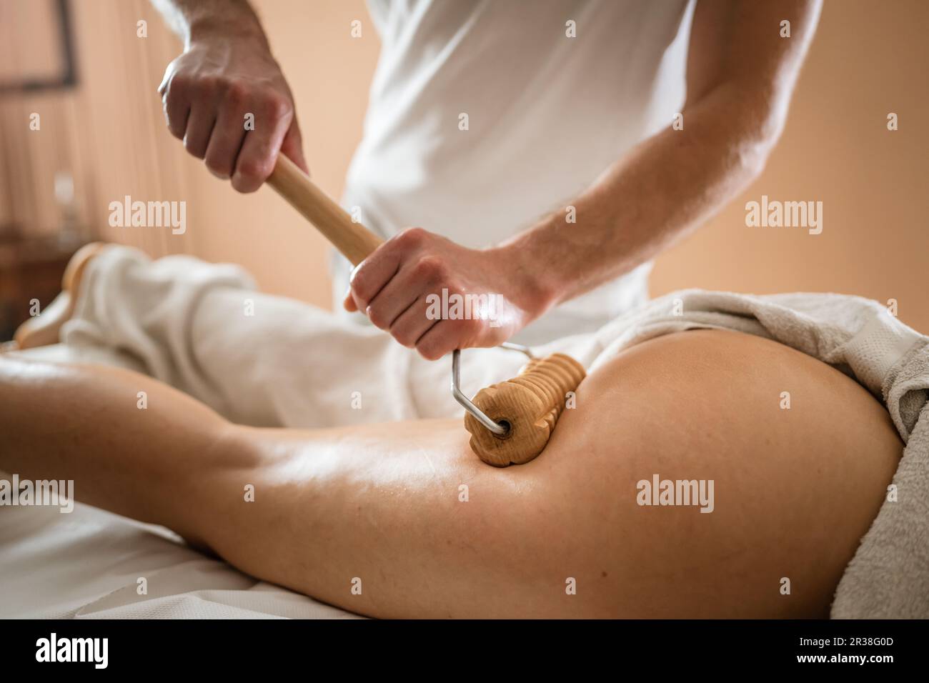 Inconnu Femme caucasienne ayant madero thérapie massage anti-cellulite traitement par thérapeute professionnel tenant des outils en bois dans les mains en studio ou sa Banque D'Images