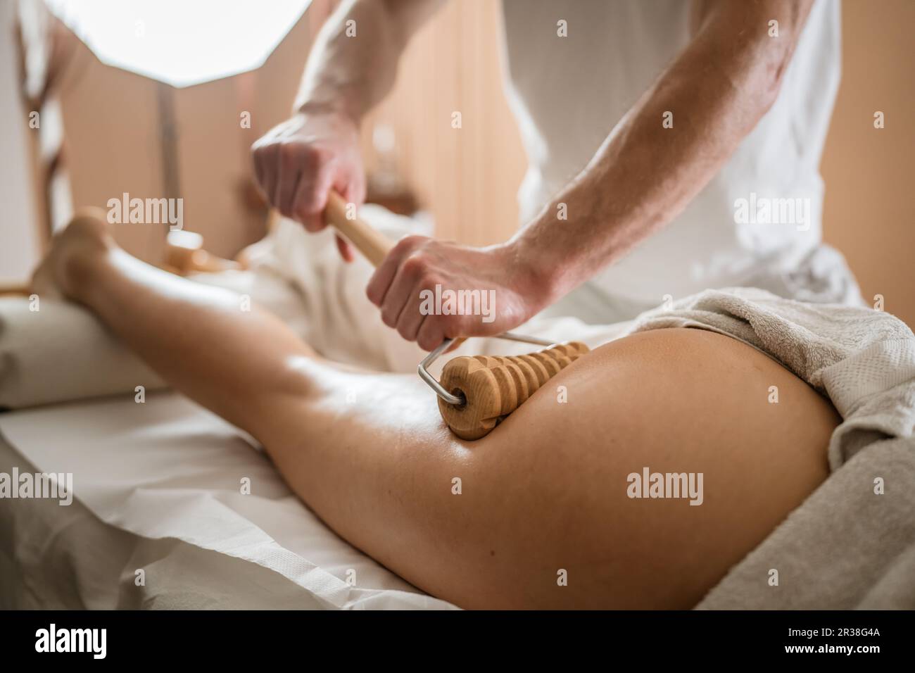 Inconnu Femme caucasienne ayant madero thérapie massage anti-cellulite traitement par thérapeute professionnel tenant des outils en bois dans les mains en studio ou sa Banque D'Images