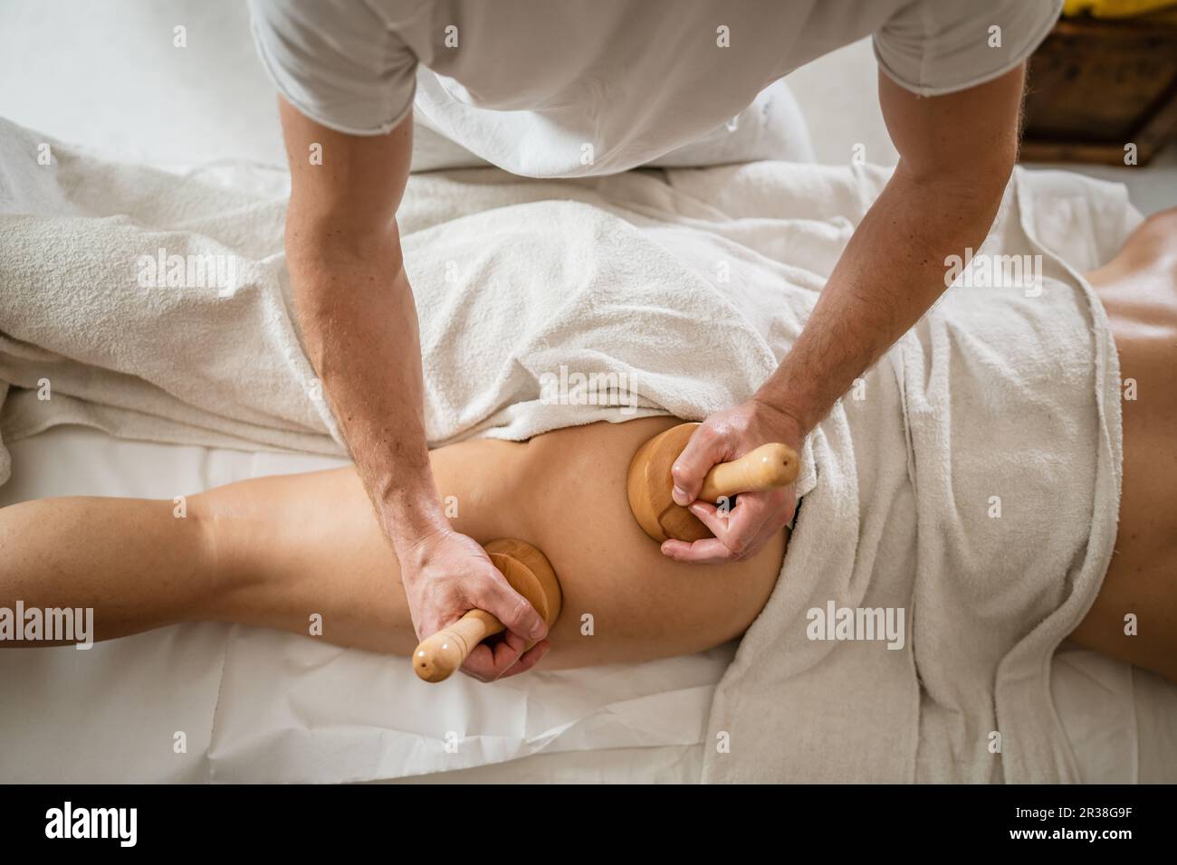 Inconnu Femme caucasienne ayant madero thérapie massage anti-cellulite traitement par thérapeute professionnel tenant des outils en bois dans les mains en studio ou sa Banque D'Images