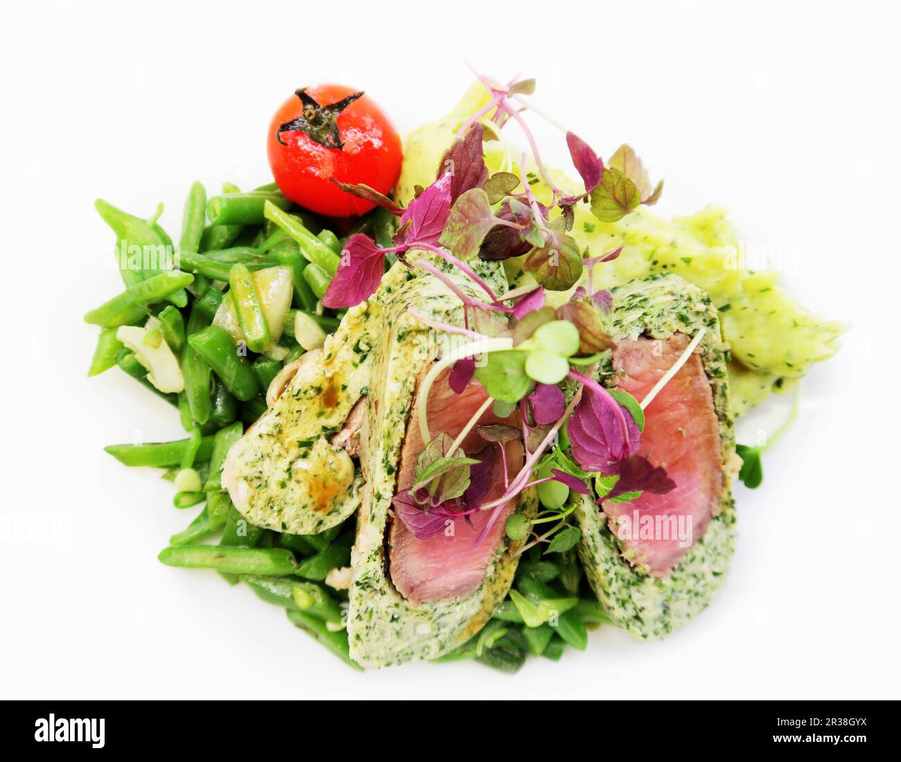 Filet d'agneau dans un revêtement de strudel aux herbes sur un lit de légumes Banque D'Images