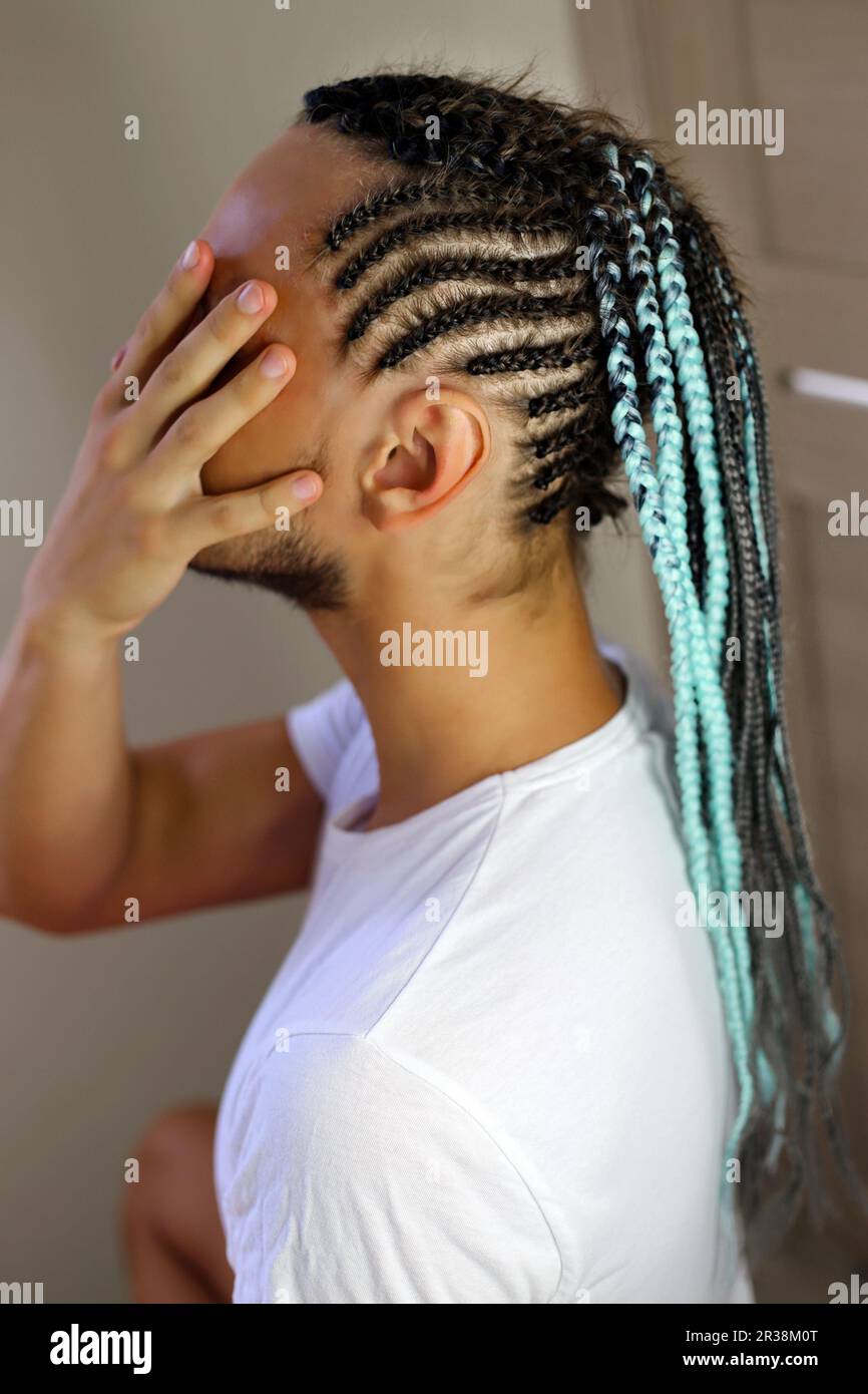 Un homme tressé avec des tresses africaines, une coiffure avec une couleur menthe Banque D'Images