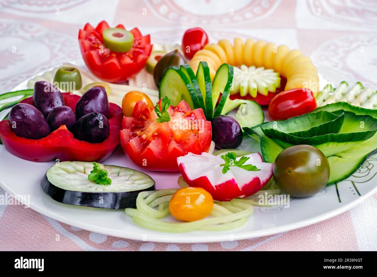 Assiette de plats végétariens pour le petit déjeuner avec concombre, tomate, olives vertes, spirale de pommes de terre, fromage jaune et poivron rouge sur le blanc Banque D'Images