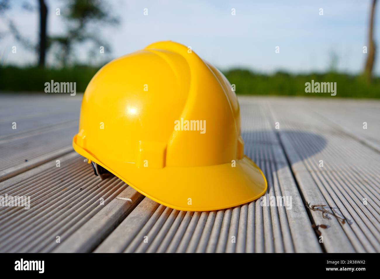 Casque de construction sur fond en bois. Casque de sécurité jaune. Banque D'Images