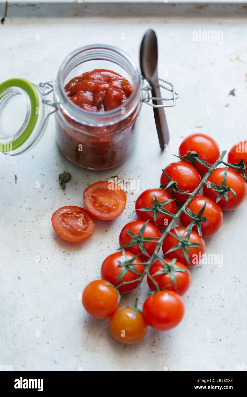 Sauce tomate dans un verre et tomates cerises fraîches Banque D'Images