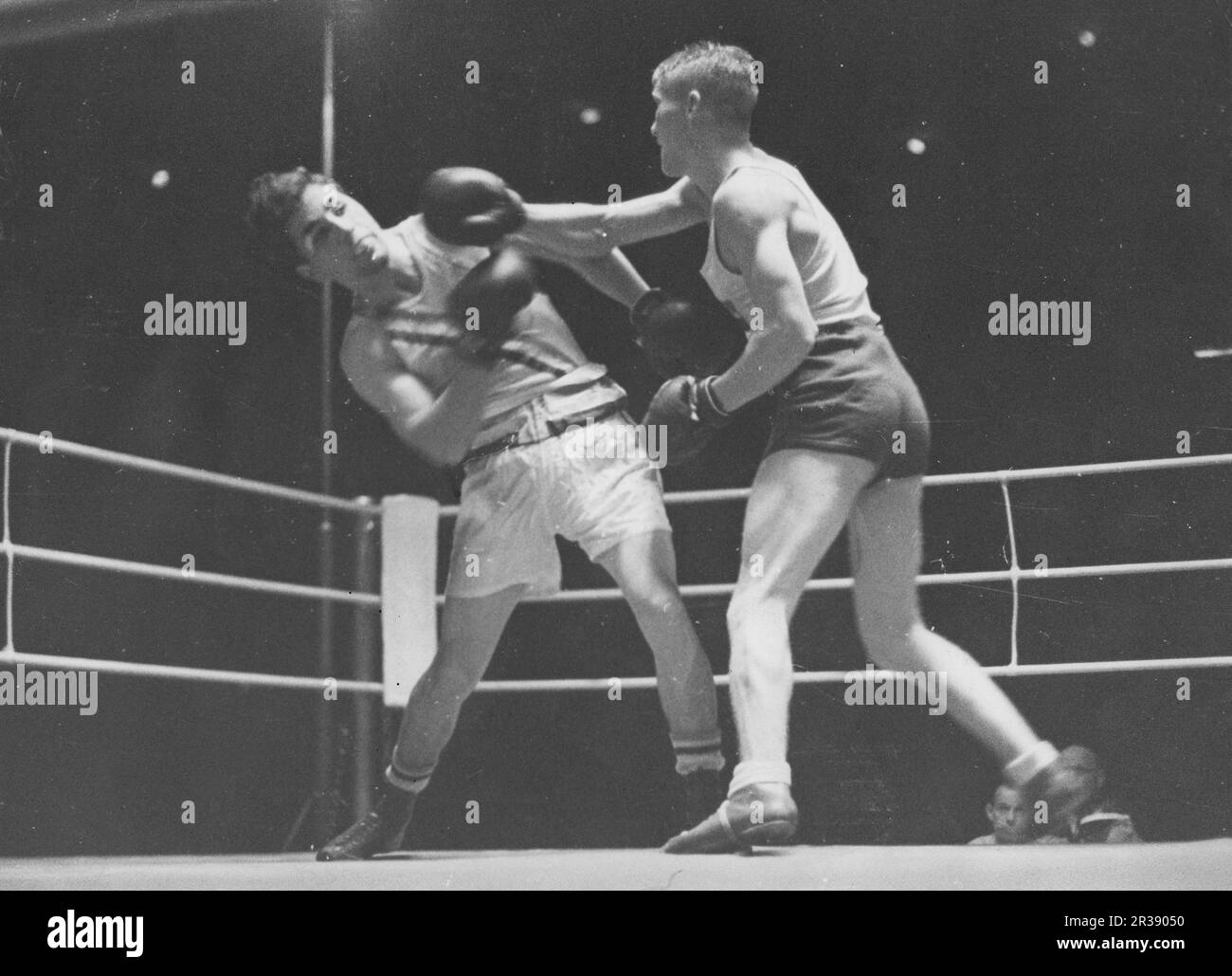 Jeux olympiques de Berlin 1936. Les Jeux Olympiques d'été 1936 (en allemand : Olympiche Sommerspiele 1936), officiellement connus sous le nom de Jeux de la XI e Olympiade (en allemand : Spiele der XI Olympiade), connue sous le nom de Berlin 1936, était un événement multisport international qui s'est tenu du 1 au 16 août 1936 à Berlin, en Allemagne. Photo du boxeur suédois léger Erik Ågren dans le match de boxe en bronze contre le boxeur américain Scrivani. Banque D'Images