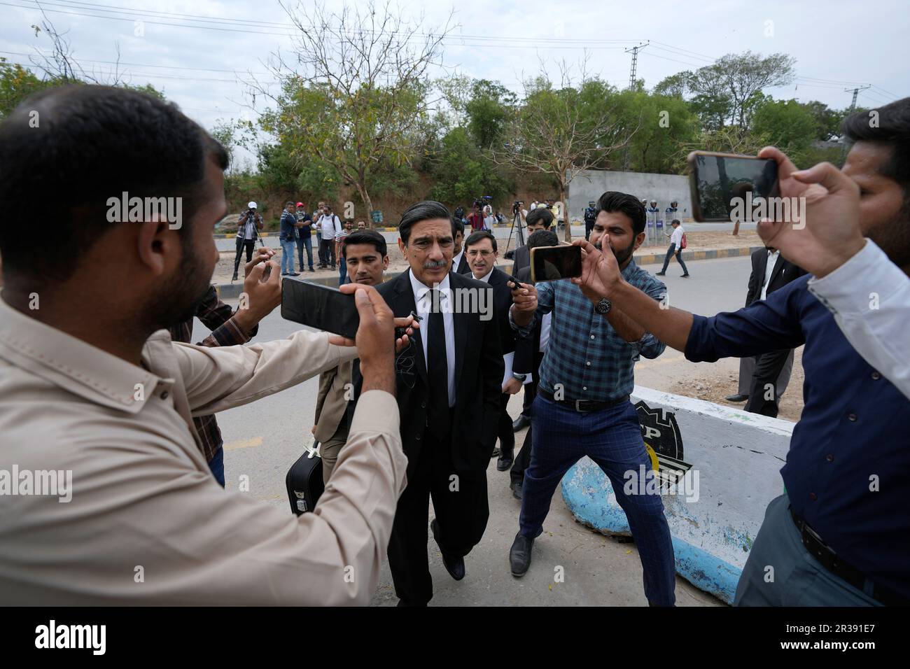 Khawaja Haris, center, lawyer of Pakistan's former Prime Minister Imran Khan, is surrounded by members of media as he arrives to appear in court, in Islamabad, Pakistan, Tuesday, May 23, 2023. Khan on Tuesday pressed his legal battle before a court in the capital, Islamabad, which granted him protection from arrest until early next month in several cases where he faces terrorism charges for inciting violence. (AP Photo/Anjum Naveed) Banque D'Images