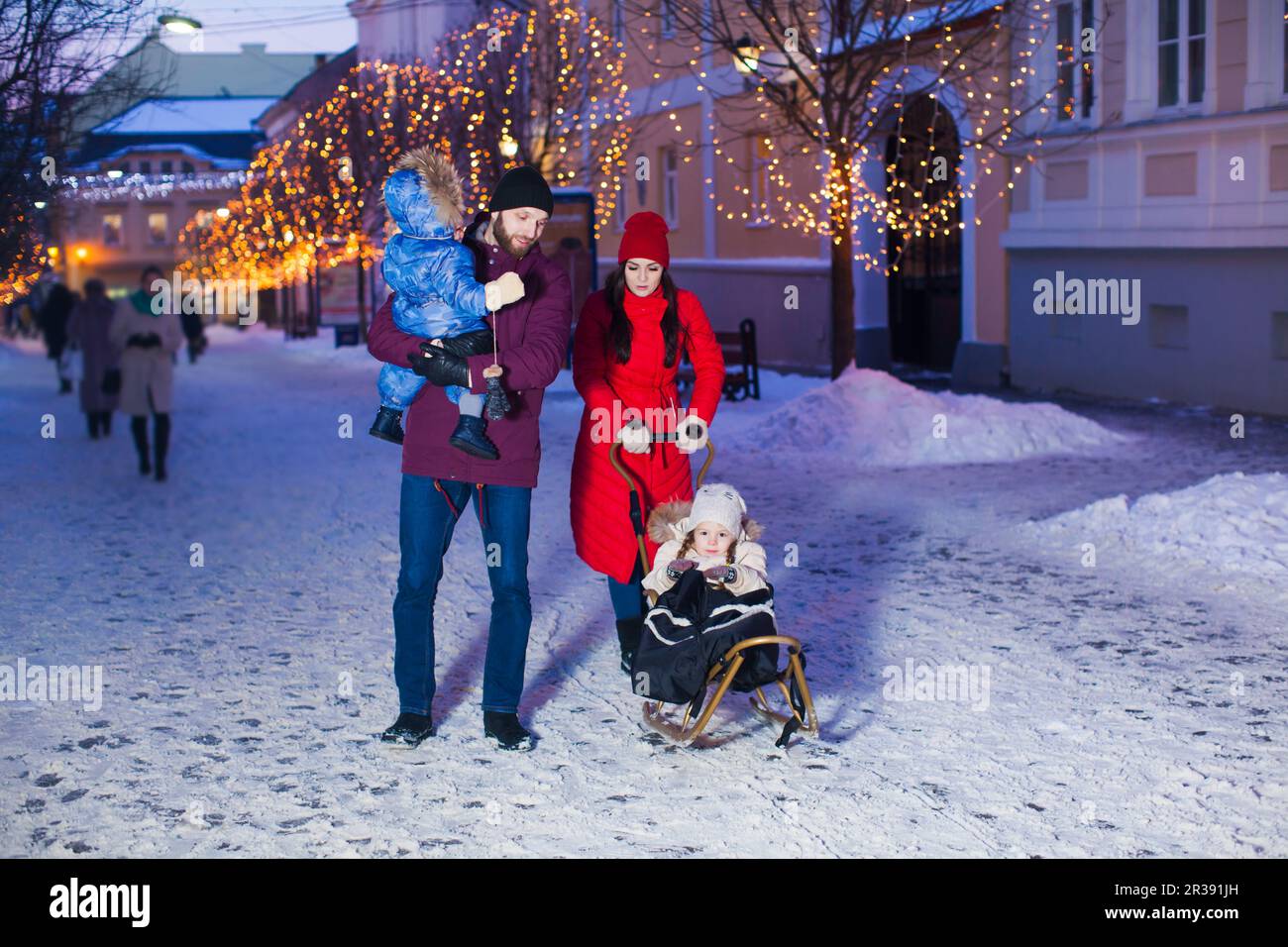Belle famille pendant la marche d'hiver avec fond de ville Banque D'Images