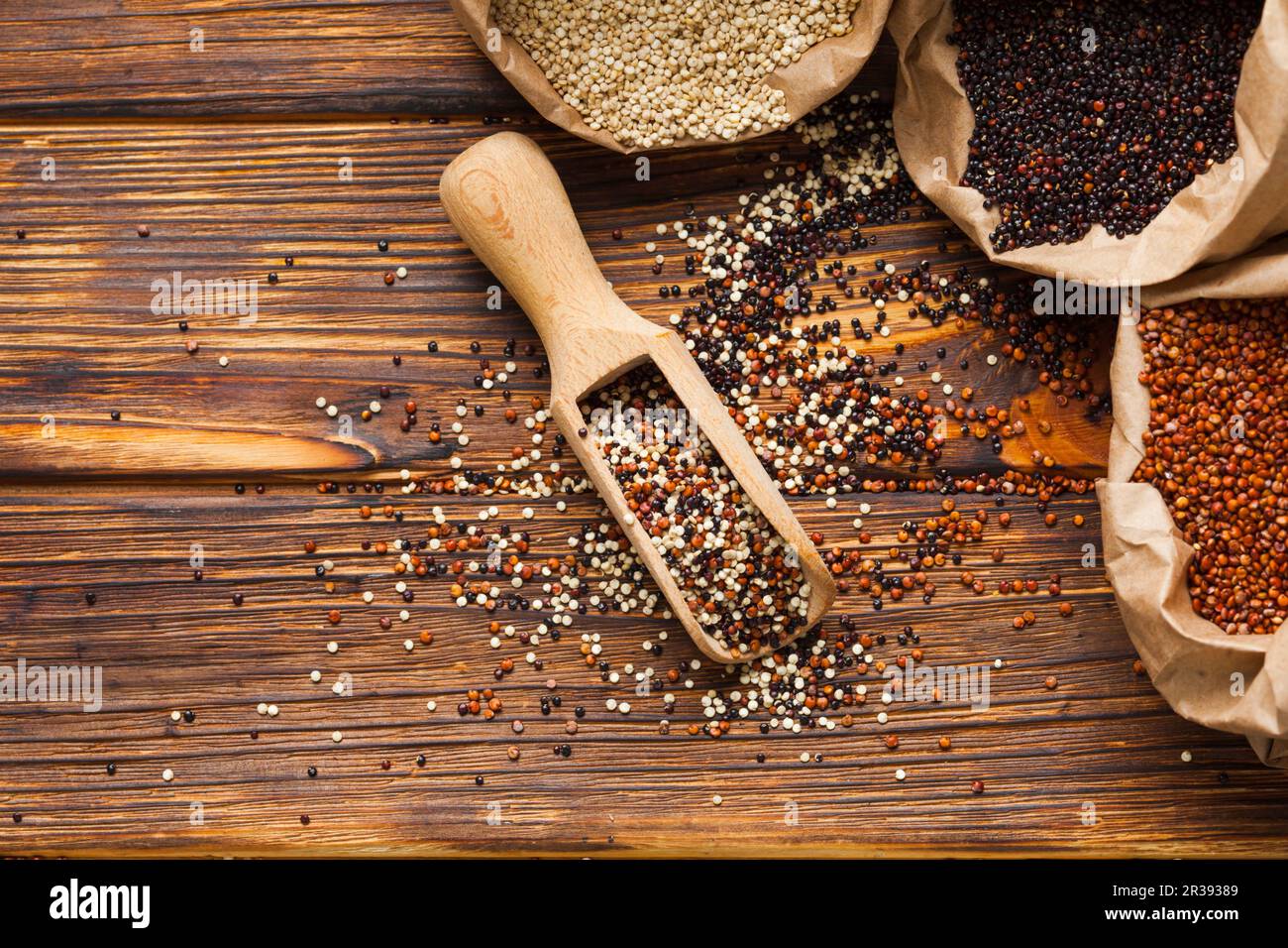 Le quinoa dans la boule en bois se disperse sur la table en bois Banque D'Images