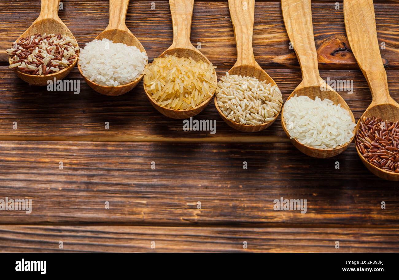 Pelles en bois avec différents types de riz sur la table Banque D'Images