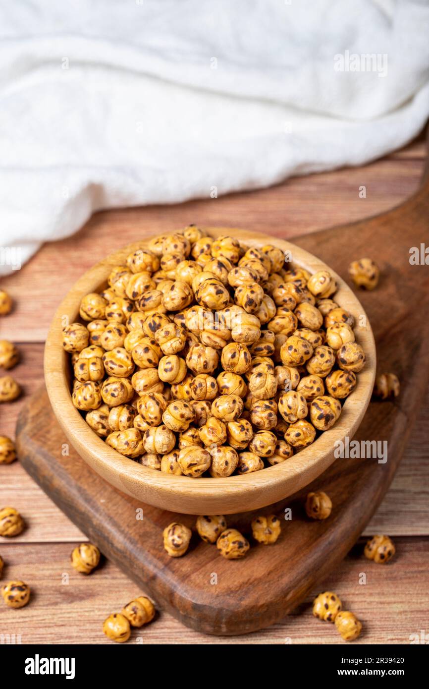 Pois chiches rôtis. Pois chiches rôtis dans un bol en bois. Superfood concept de la nourriture végétarienne. des collations saines. Gros plan Banque D'Images
