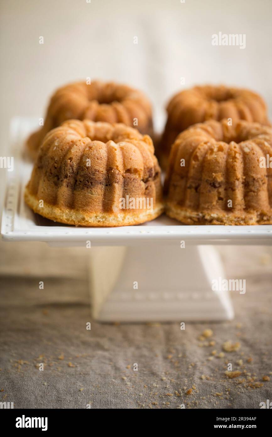 Quatre mini-gâteaux au café avec amandes sur un support à gâteau Banque D'Images