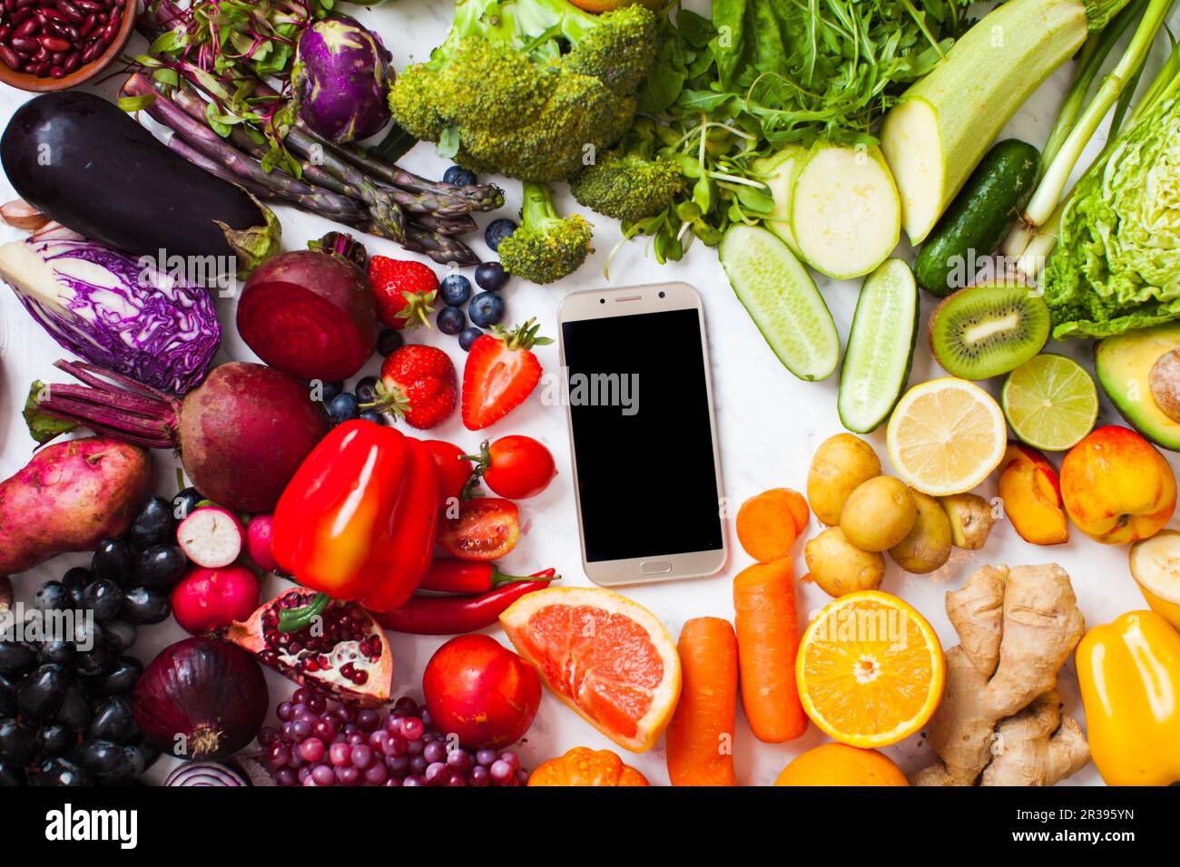 Produits agricoles, smartphone avec nourriture végétalienne arc-en-ciel, vue du dessus Banque D'Images