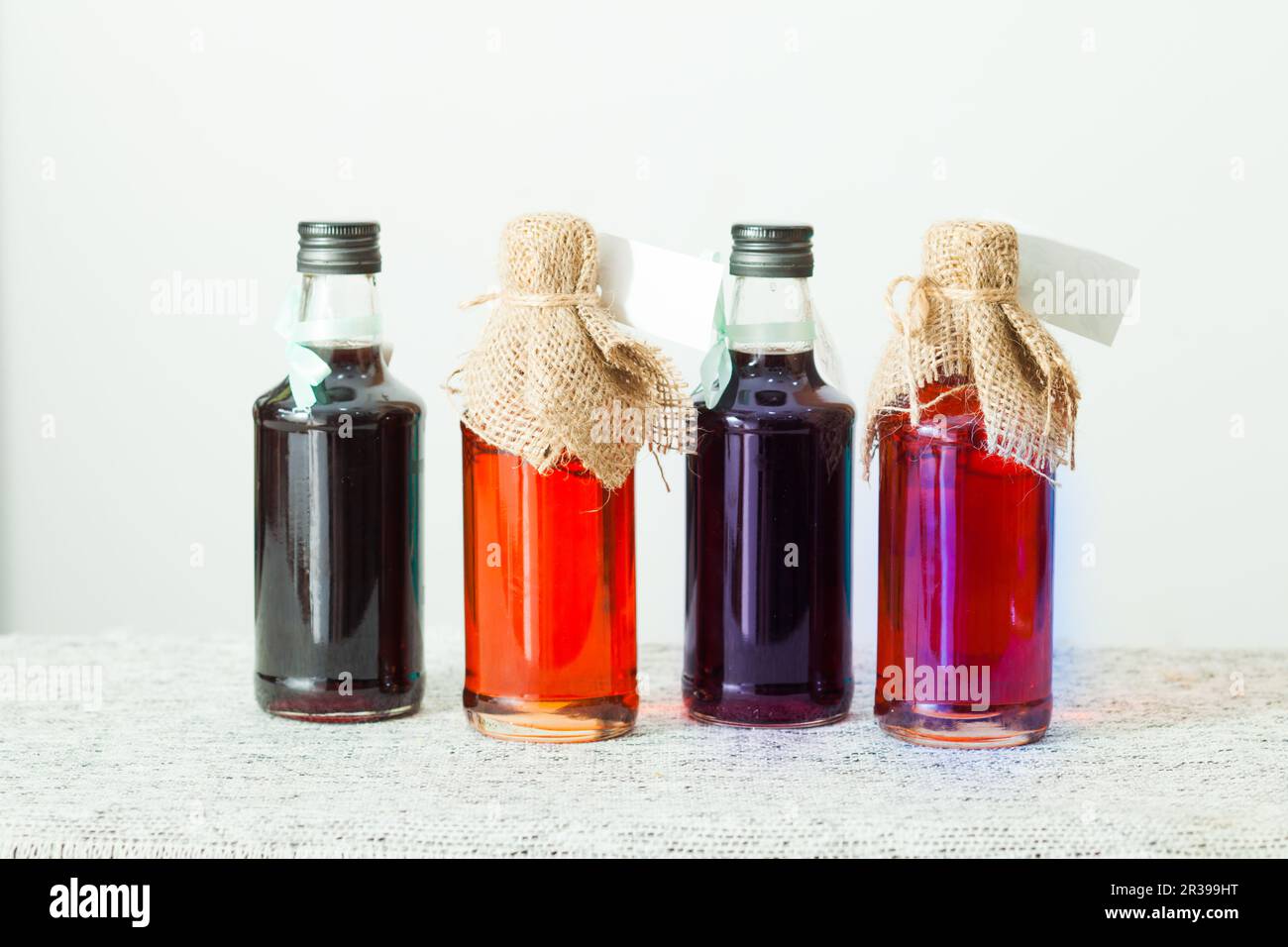 Maison savoureux sirop de fruits en bouteilles, sur un plateau blanc Banque D'Images