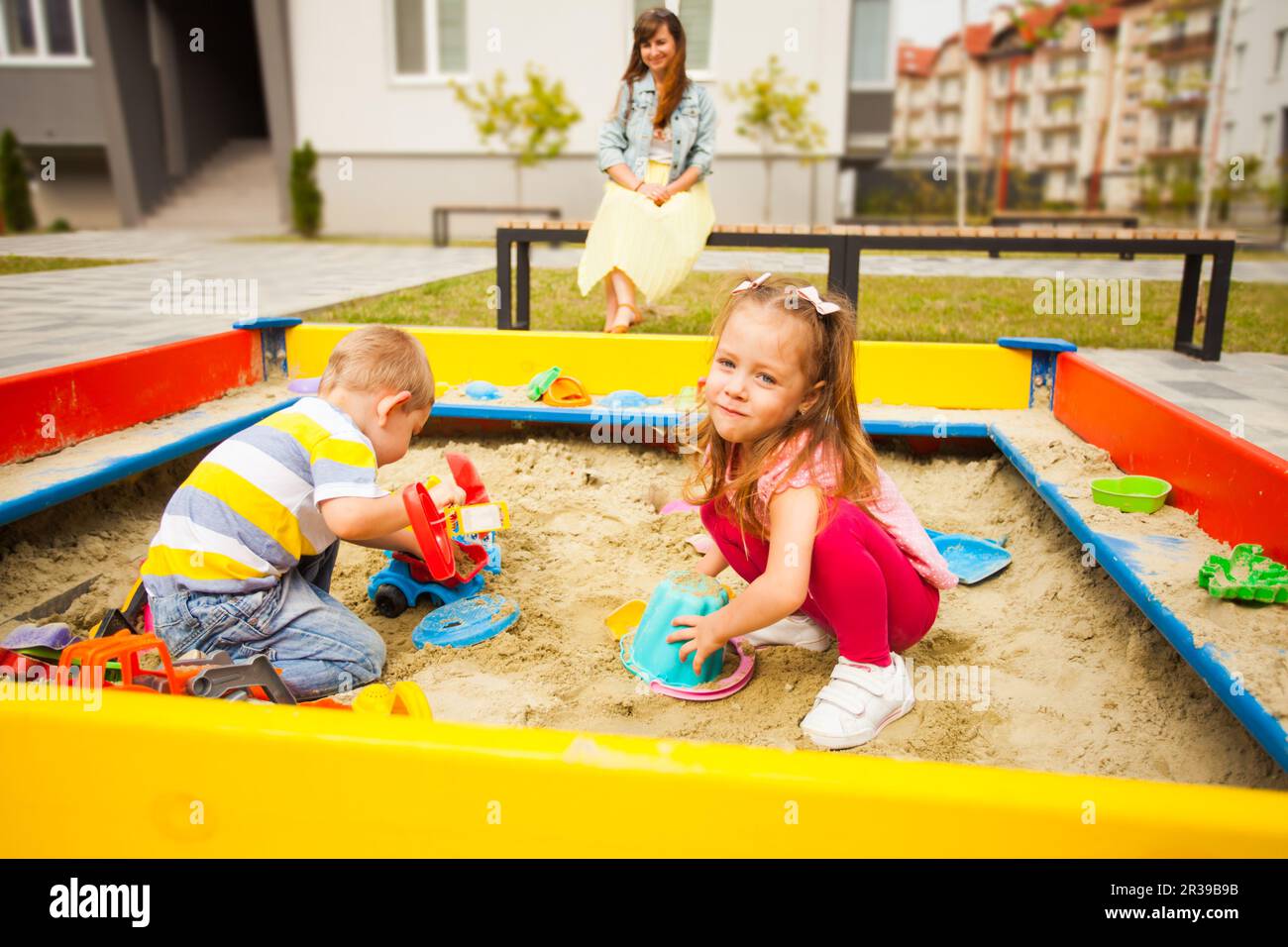 Petite fille et bébé fils jouer ensemble en sandbox moderne Banque D'Images