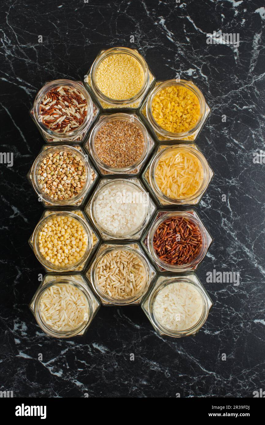 Diverses céréales, riz, couscous, boulgur et sarrasin en pots de verre, vue de dessus Banque D'Images