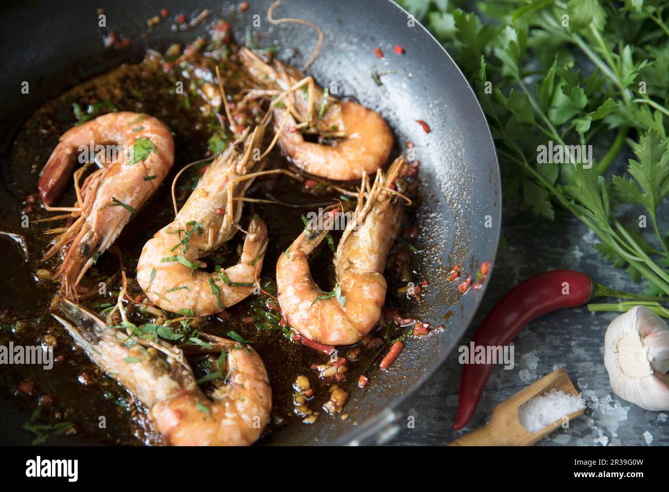 Crevettes cuites dans une casserole avec du Chili et de l'ail Banque D'Images