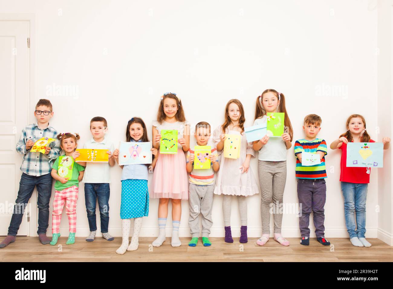 Groupe d'enfants tenant leurs objets artisanaux Banque D'Images