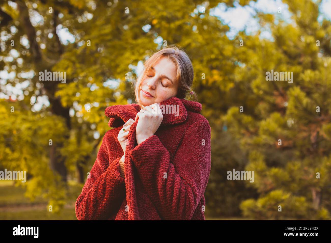 Femme se enveloppant dans un élégant manteau d'automne Banque D'Images
