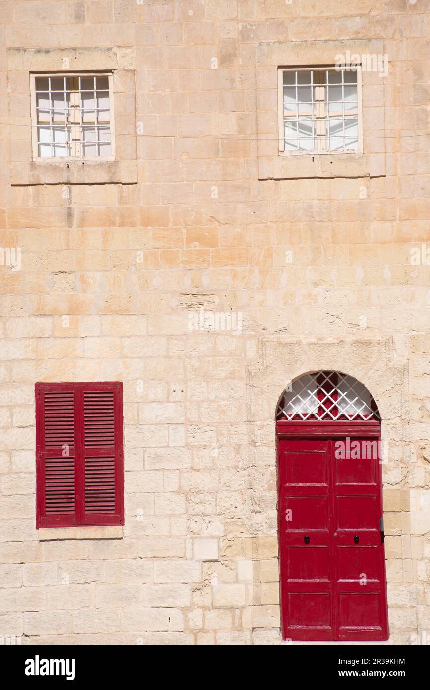 Porte rouge et fenêtres traditionnelle en pierre maison murale mdina Malte Banque D'Images