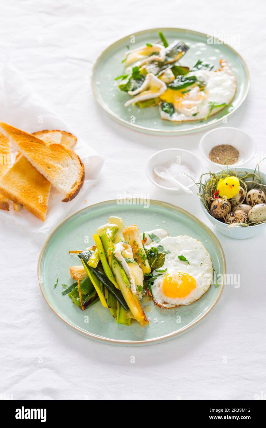 Poireau braisé avec camembert fondu et œufs frits Banque D'Images